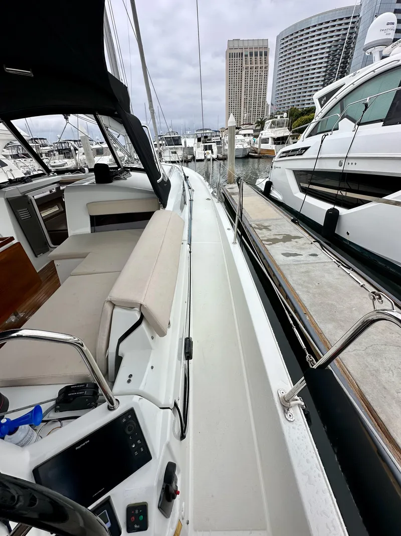 Slide: The Image of 2020 Jeanneau Sun Odyssey 490 docked at marina, featuring spacious deck and modern design. - 27