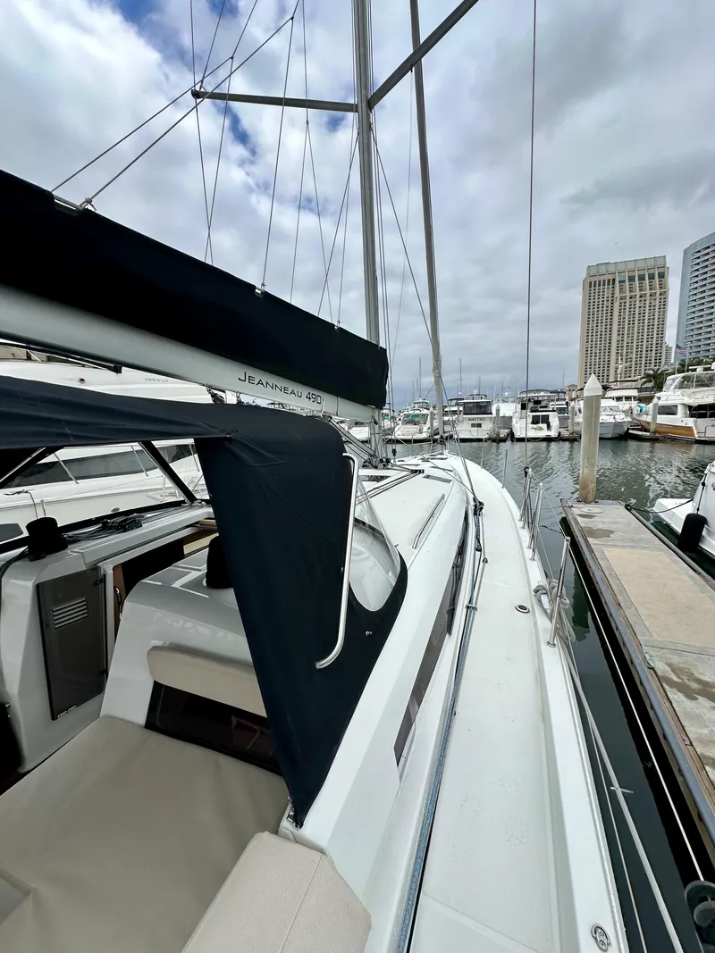 Slide: The Image of 2020 Jeanneau Sun Odyssey 490 sailboat docked in marina, cloudy sky. - 28