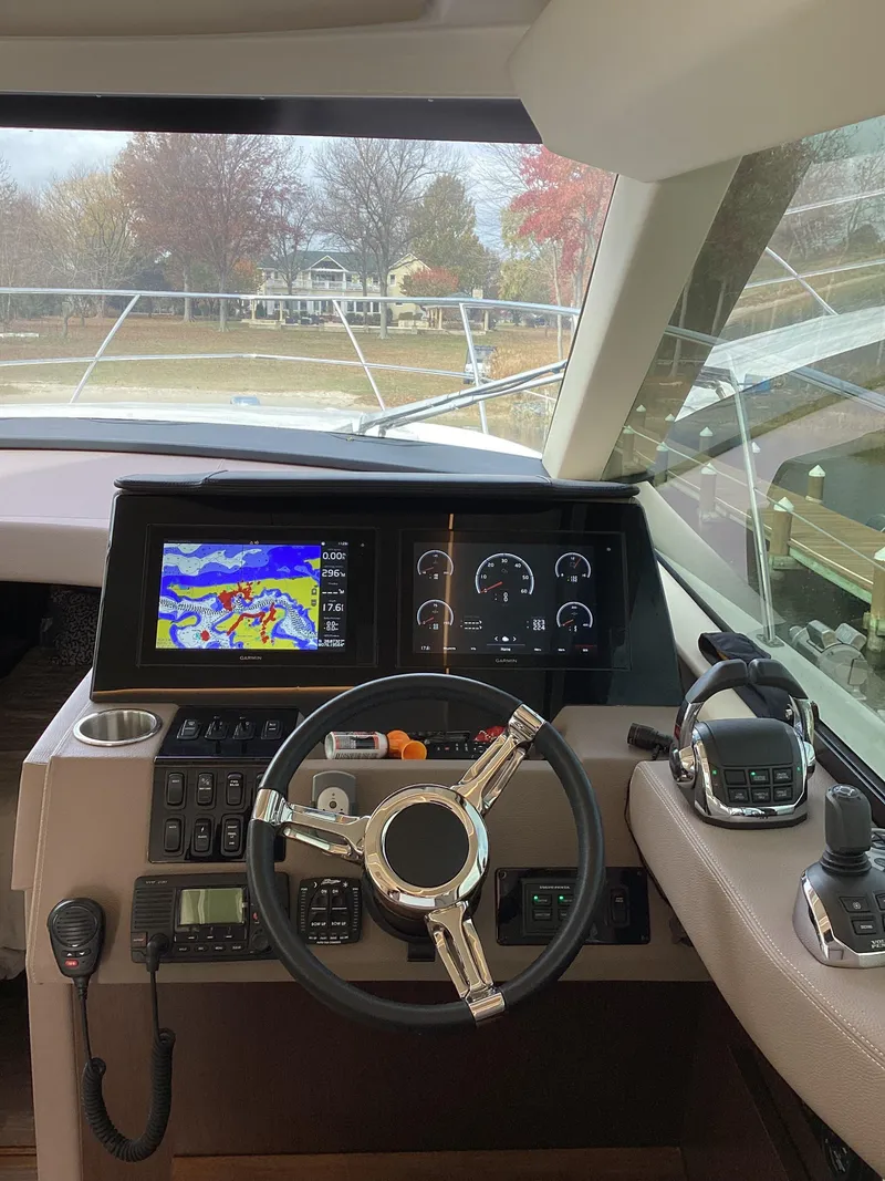Slide: The Image of 2018 Regal 42 Fly yacht helm with navigation screens and controls. - 11