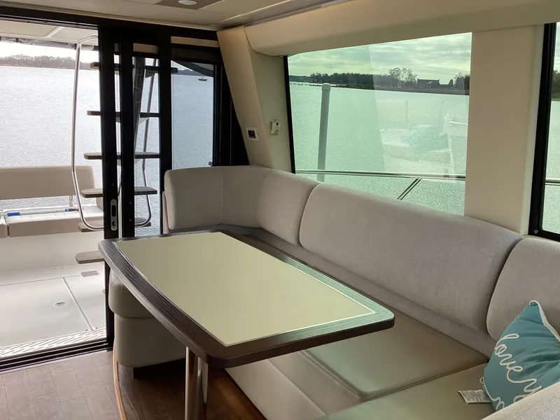 Slide: The Image of Interior of 2018 Regal 42 Fly yacht with elegant seating and table by large windows. - 13