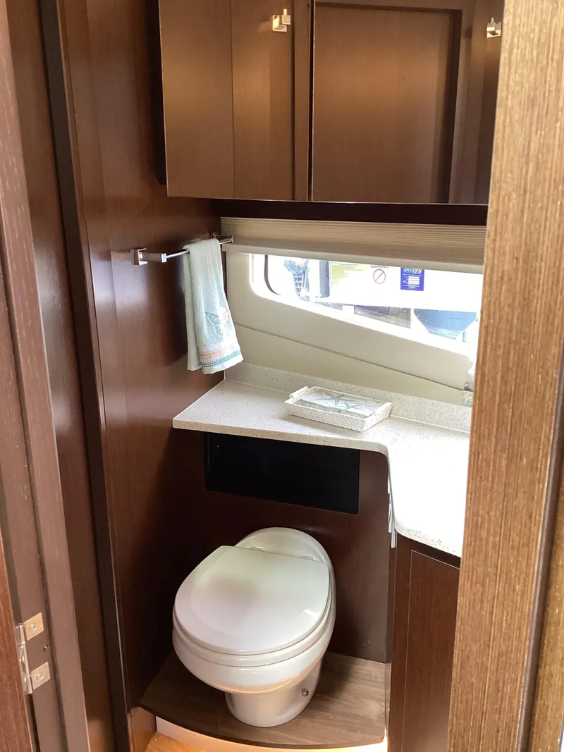 Slide: The Image of 2018 Regal 42 Fly yacht bathroom with modern fixtures and wood cabinetry. - 17