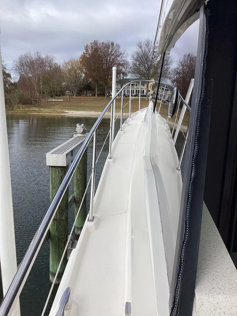 Slide: The Image of Side view of 2018 Regal 42 Fly yacht docked by a calm waterfront. - 20