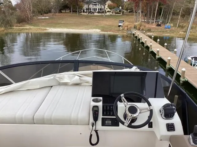 Slide: The Image of 2018 Regal 42 Fly yacht helm with scenic waterfront view. - 21