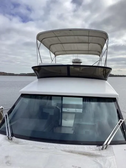 Slide: The Image of 2018 Regal 42 Fly yacht with flybridge, docked on a cloudy day. - 29