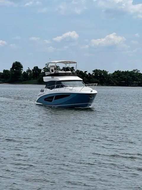 Slide: The Image of 2018 Regal 42 Fly yacht cruising on a calm lake under a partly cloudy sky. - 3