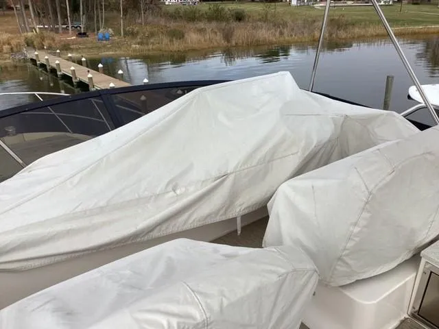 Slide: The Image of Covered 2018 Regal 42 Fly boat docked by a serene waterfront. - 31