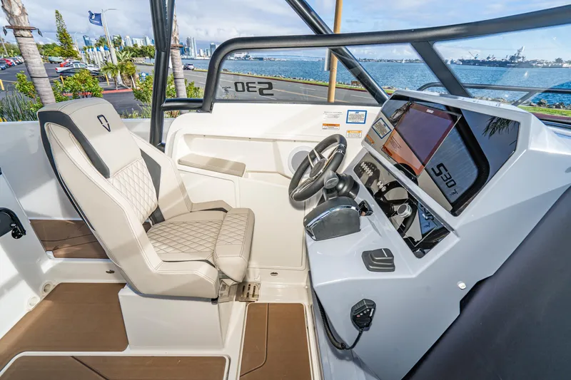 Slide: The Image of 2025 Navan S30 boat interior with modern dashboard and steering, overlooking a scenic waterfront. - 23