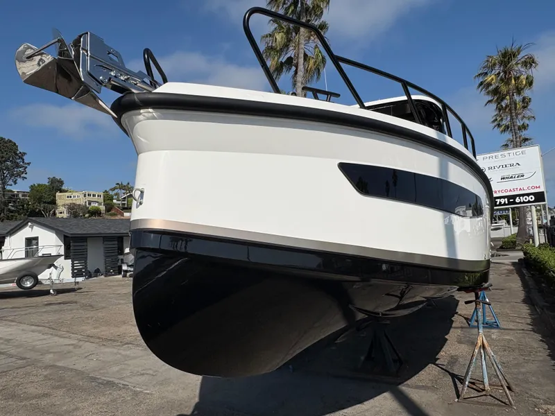 Slide: The Image of 2025 Navan S30 boat on display, elevated on stands, with clear blue sky background. - 1