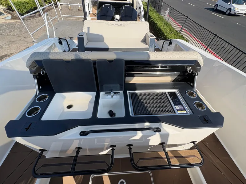 Slide: The Image of Navan S30 2025 boat with outdoor kitchen, featuring sink, grill, and cup holders. - 12