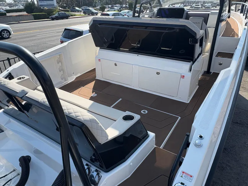 Slide: The Image of 2025 Navan S30 boat interior with seating and storage, parked near a road. - 4