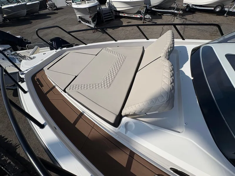 Slide: The Image of 2025 Navan S30 boat with cushioned sunbathing area, docked among other boats. - 7