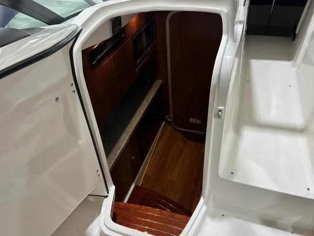 Slide: The Image of 2021 Chaparral 347 SSX cabin interior with wood flooring and kitchenette. - 17