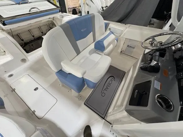 Slide: The Image of 2024 Robalo R250 boat interior with seating, cup holder, and speaker. - 2