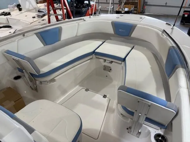 Slide: The Image of 2024 Robalo R250 boat interior with blue and white seating in a showroom. - 7