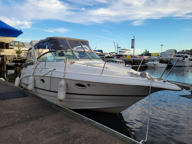 Slide: The Image of 1997 Larson 290 Cabrio boat docked at marina under blue sky. - 1