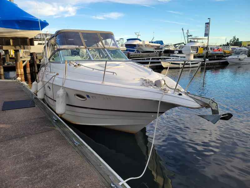Slide: The Image of 1997 Larson 290 Cabrio boat docked at marina under clear sky. - 2