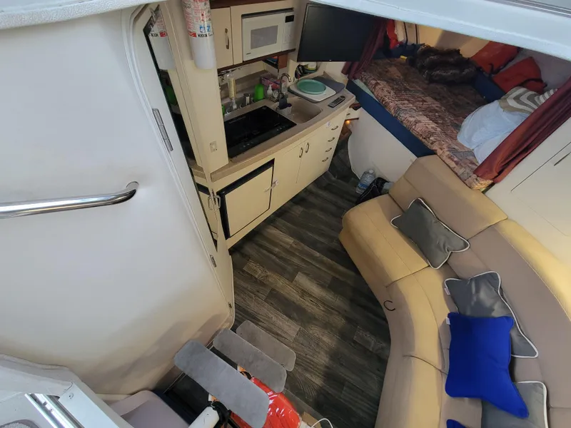 Slide: The Image of Interior of 1997 Larson 290 Cabrio boat with kitchenette and seating area. - 27