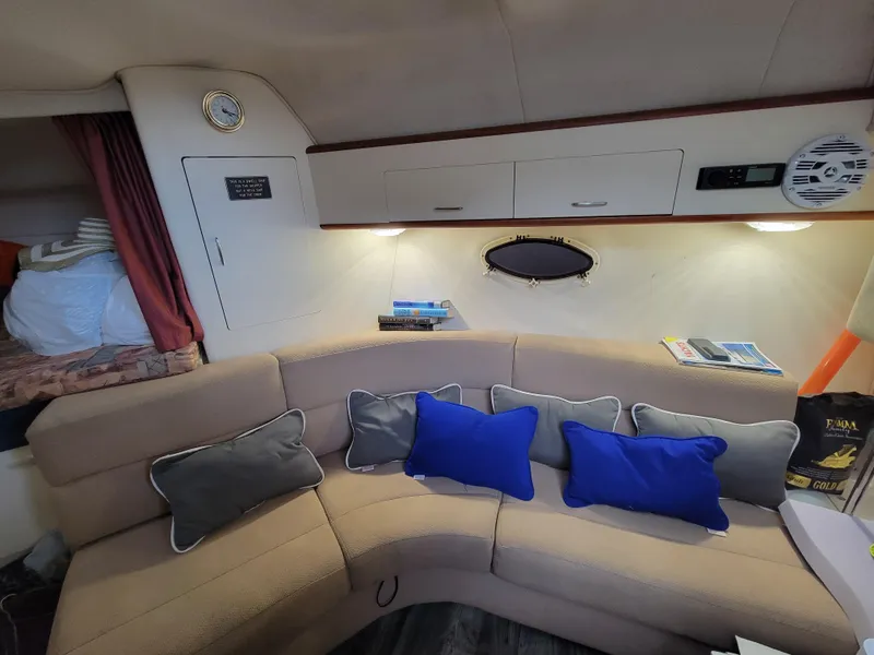 Slide: The Image of Interior of 1997 Larson 290 Cabrio boat with beige seating and blue cushions. - 29