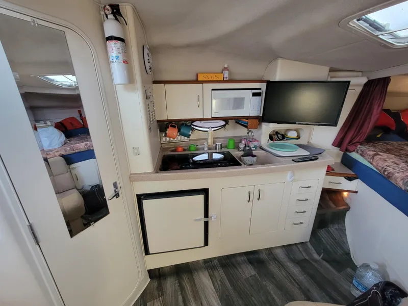 Slide: The Image of Interior of 1997 Larson 290 CABRIO boat with kitchenette and modern amenities. - 31