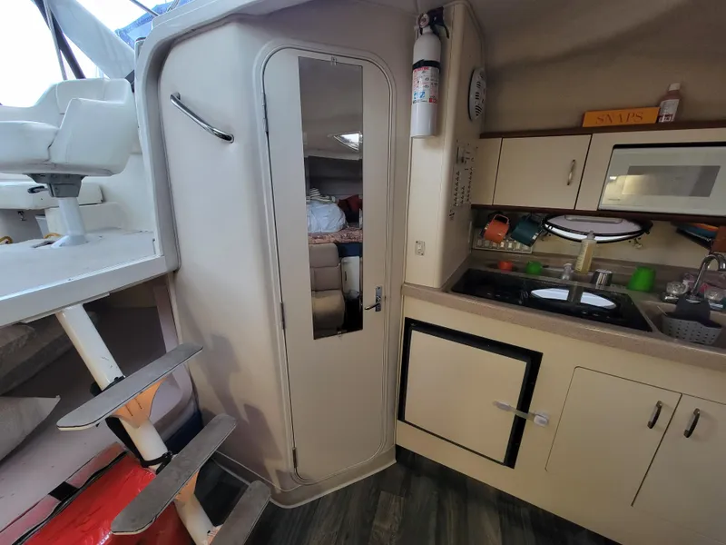 Slide: The Image of Interior of 1997 Larson 290 CABRIO boat with kitchenette and stairs. - 32