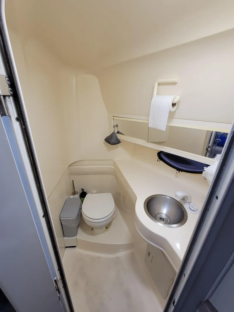 Slide: The Image of 1997 Larson 290 CABRIO boat bathroom with toilet, sink, and mirror. - 33