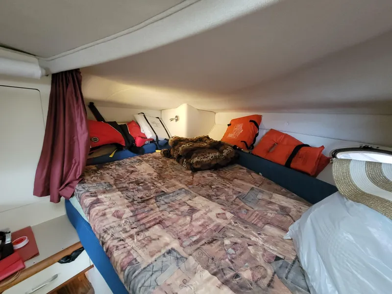 Slide: The Image of Cozy cabin interior of 1997 Larson 290 Cabrio with bed and life jackets. - 37