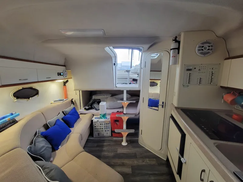 Slide: The Image of Interior of 1997 Larson 290 Cabrio boat with cozy seating and kitchenette. - 38