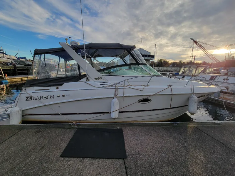 Slide: The Image of 1997 Larson 290 Cabrio boat docked at marina under cloudy sky. - 4