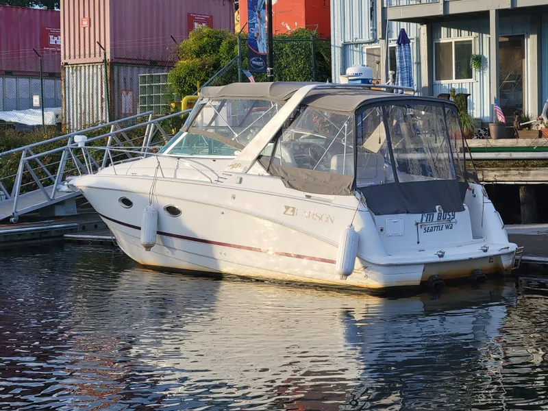 Slide: The Image of 1997 Larson 290 Cabrio boat docked at marina with protective cover. - 9