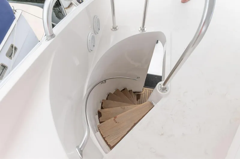 Slide: The Image of Spiral staircase on 2004 Bertram 630 yacht with sleek white design. - 16