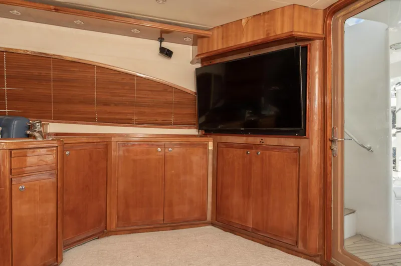 Slide: The Image of Luxurious interior of 2004 Bertram 630 yacht with wooden cabinetry and flat-screen TV. - 18