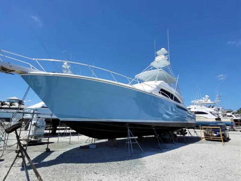 Slide: The Image of 2004 Bertram 630 yacht on dry dock under clear blue sky. - 2