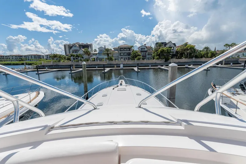 Slide: The Image of View from 2004 Bertram 630 yacht in marina, with waterfront homes and blue sky. - 21