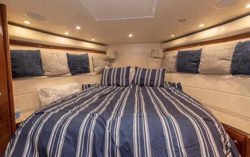 Slide: The Image of Luxurious cabin interior of 2004 Bertram 630 yacht with striped bedding. - 6