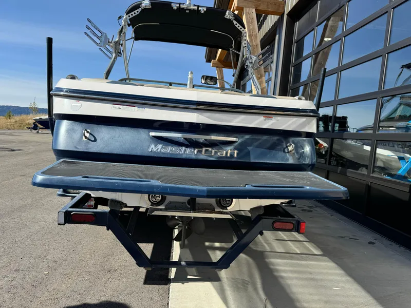Slide: The Image of 2008 MasterCraft X-15 boat rear view, parked outdoors near a building. - 10