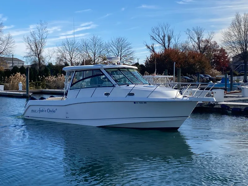 Slide: The Image of 2020 Boston Whaler 345 Conquest boat docked in a serene marina setting. - 1