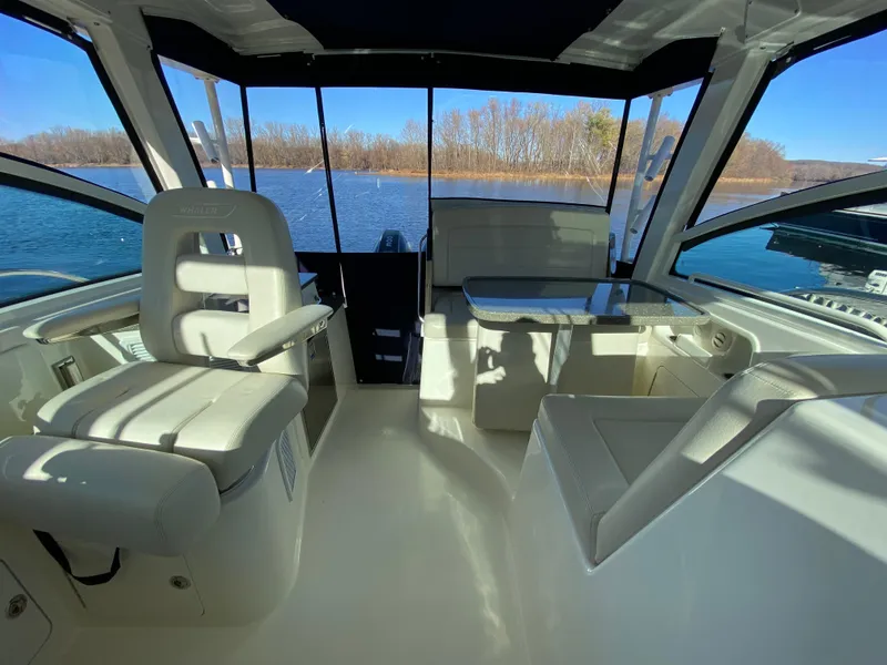 Slide: The Image of Interior of 2020 Boston Whaler 345 Conquest boat with seating and table, overlooking water. - 11