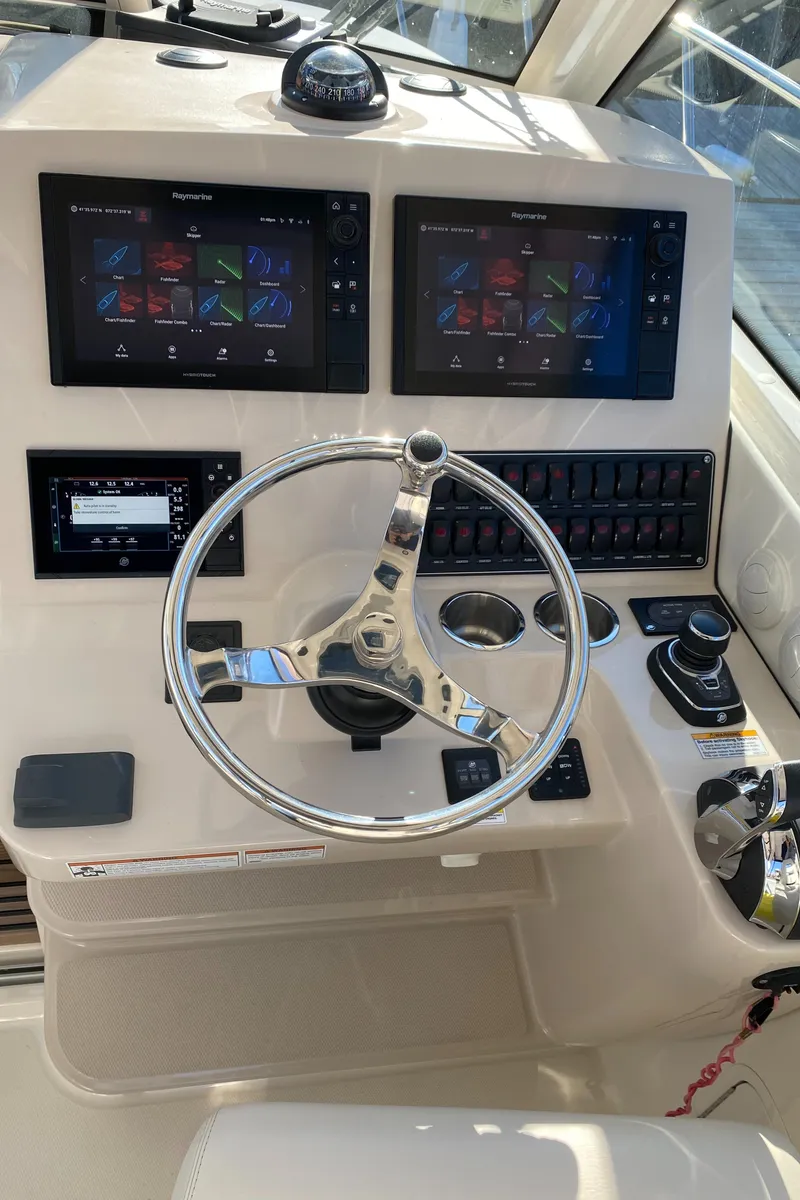 Slide: The Image of 2020 Boston Whaler 345 Conquest helm with dual displays and steering wheel. - 13