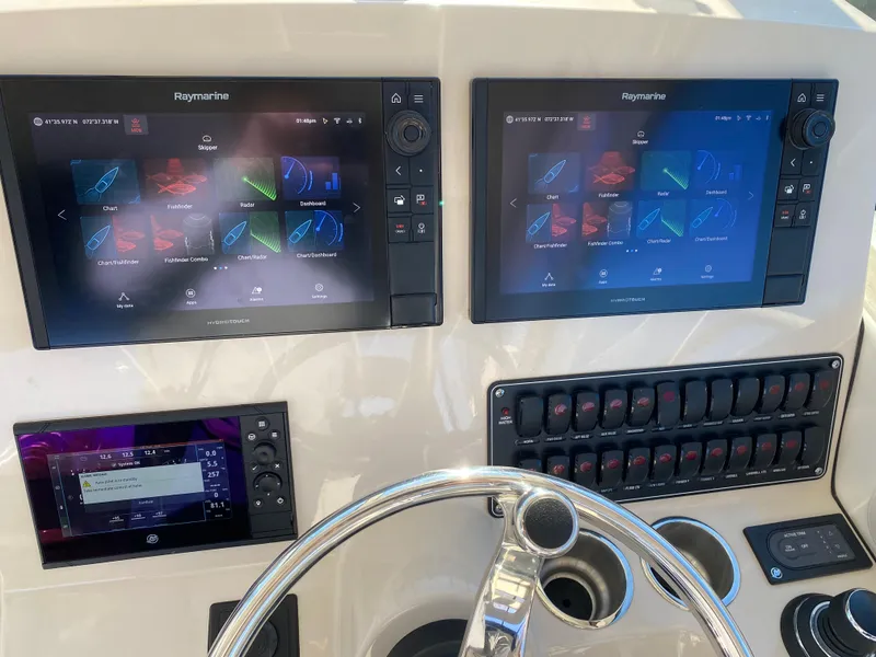 Slide: The Image of 2020 Boston Whaler 345 Conquest helm with dual Raymarine displays and control panel. - 14