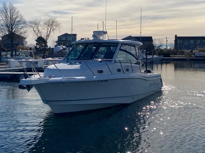 Slide: The Image of 2020 Boston Whaler 345 Conquest boat docked in a serene marina setting. - 2