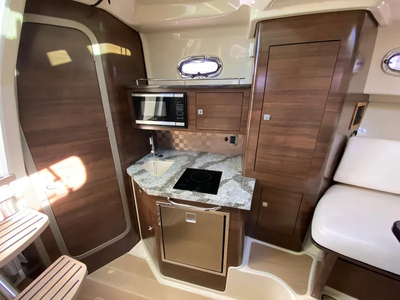 Slide: The Image of 2020 Boston Whaler 345 Conquest cabin with modern kitchenette and wood finish. - 20