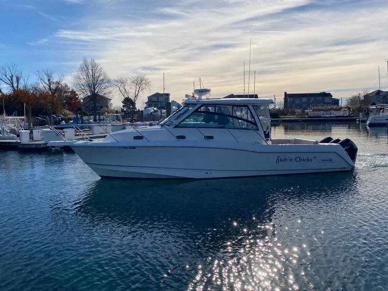 Slide: The Image of 2020 Boston Whaler 345 Conquest boat on calm water in a marina setting. - 3