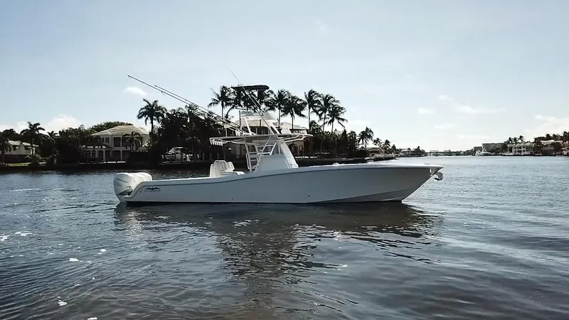 Slide: The Image of 2020 Invincible 39 Open Fisherman boat on calm water, surrounded by palm trees. - 3