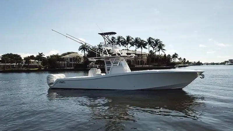 Slide: The Image of 2020 Invincible 39 Open Fisherman boat on calm water, palm trees in background. - 4