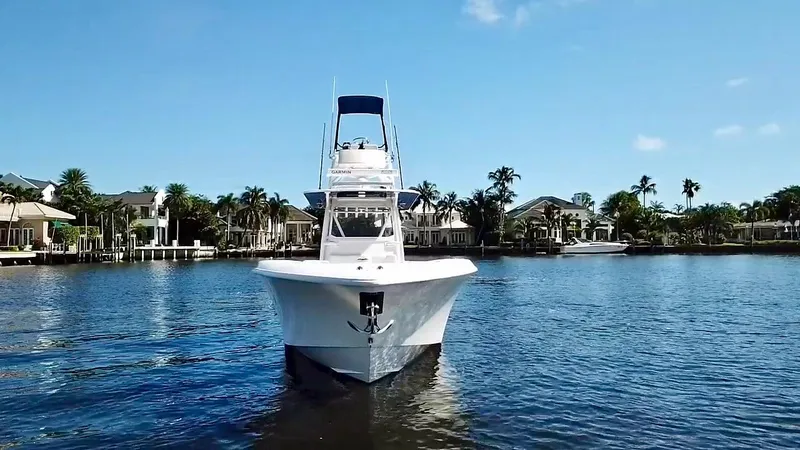 Slide: The Image of 2020 Invincible 39 Open Fisherman boat on calm water, surrounded by waterfront homes. - 7