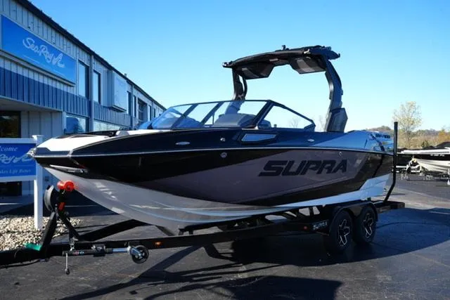 Slide: The Image of 2025 Supra SV 400 boat on trailer, parked outside dealership. - 2