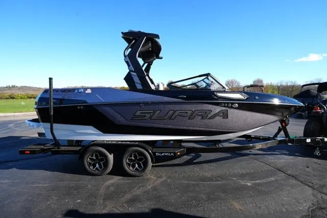 Slide: The Image of 2025 Supra SV 400 boat on trailer, sleek black design, parked outdoors. - 4