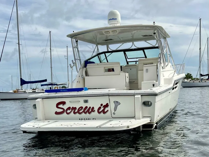 Slide: The Image of 1997 Tiara Yachts 41 boat named "Screw it" docked in a marina. - 3