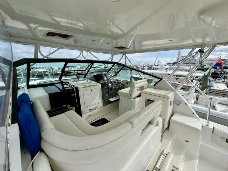 Slide: The Image of Interior of 1997 Tiara Yachts 41, featuring helm and seating area in marina setting. - 4