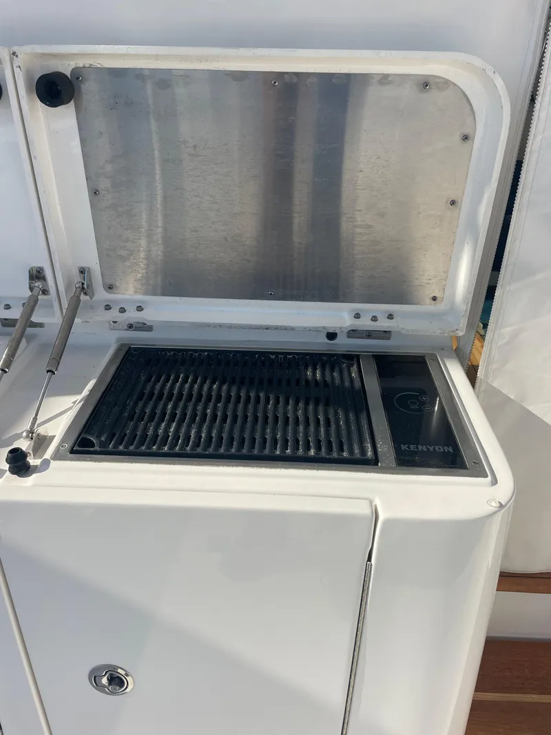 Slide: The Image of 2020 Pursuit 385 Offshore boat grill with open lid. - 10